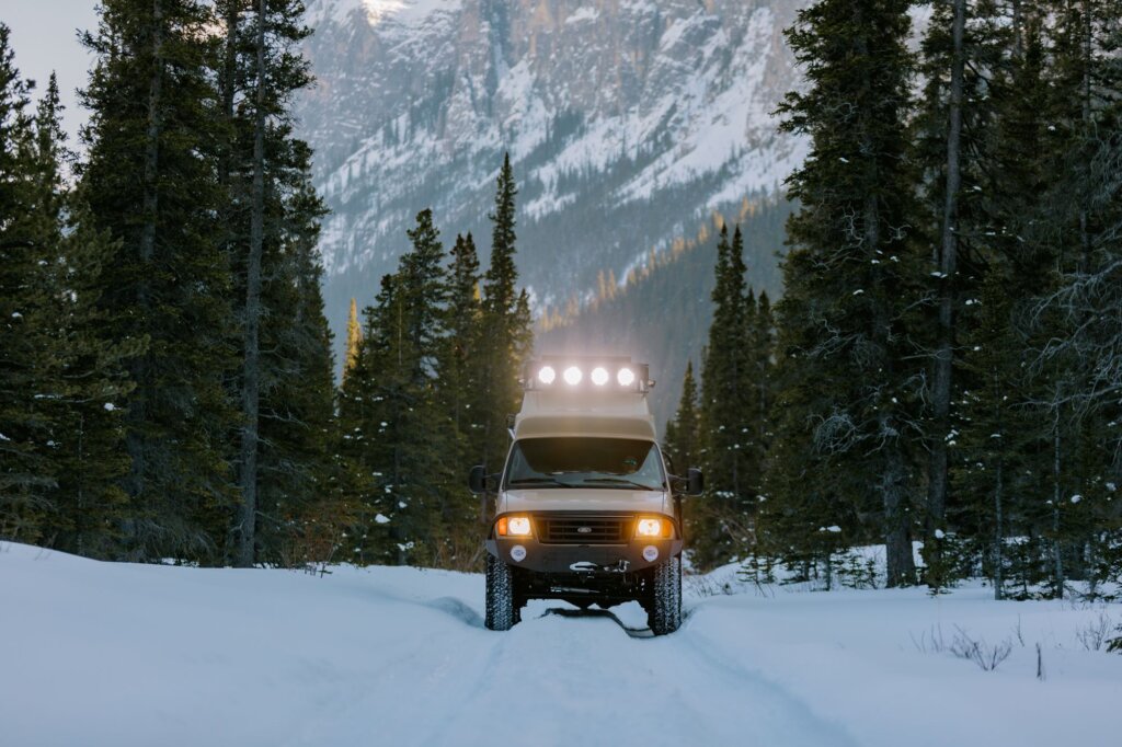 A beige Ford E-Series van in the snow.