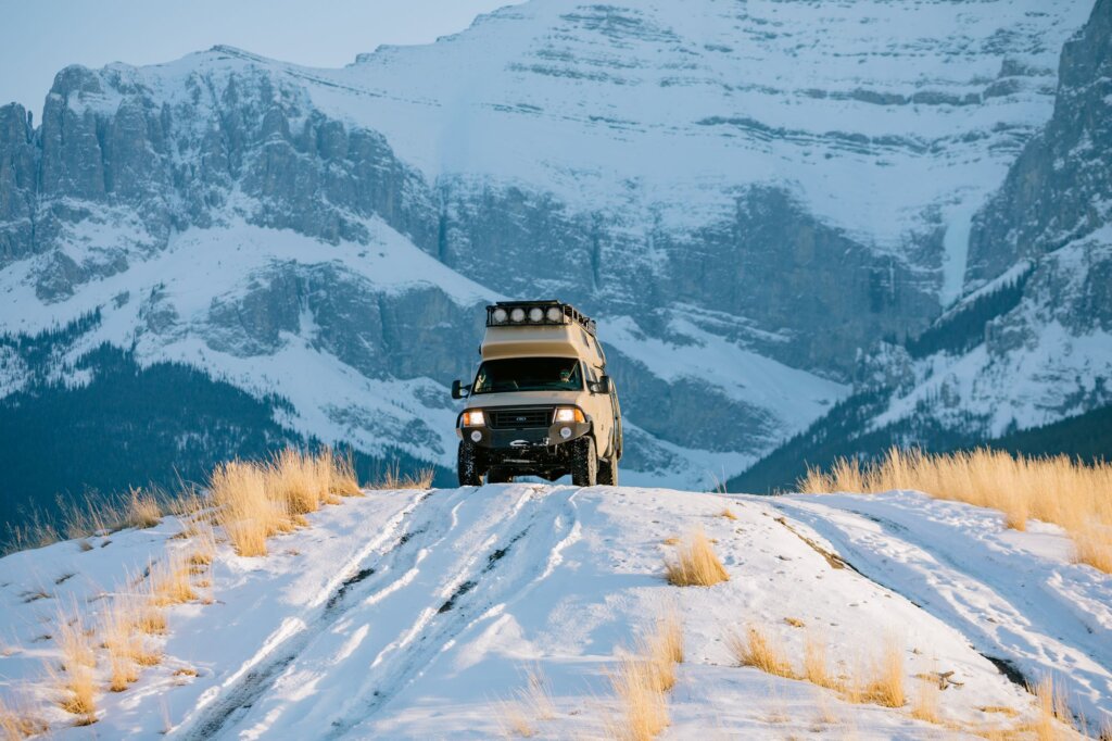 A beige Ford E-Series van off-roading.